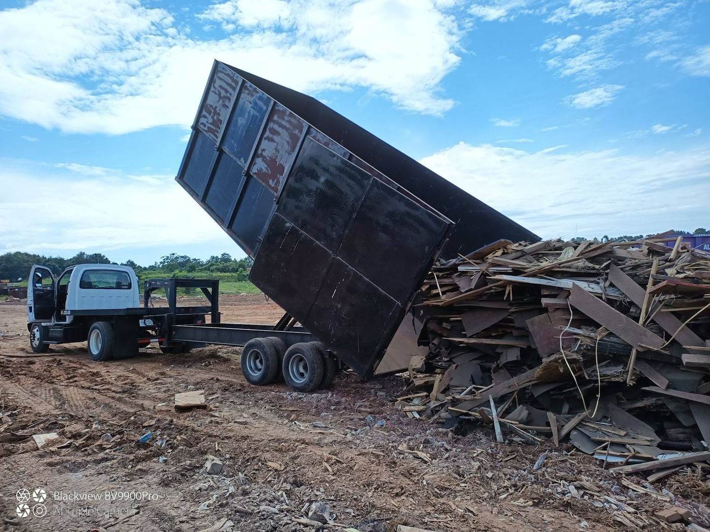 Dump trailer offloading brush and storm debris in Greer, SC