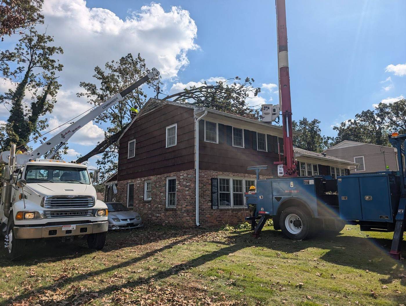 Embark crane and bucket trucks removing a storm-felled tree